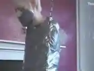 Blonde girl completely tape mummified to swing