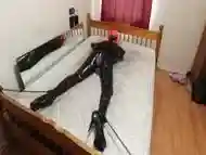 Bed Bondage In Pvc Catsuit And Chastity Belt