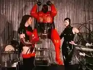 Fat Man In Latex Sits On The Sybian