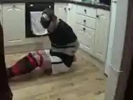 Footballer tied and taped tight on kitchen floor