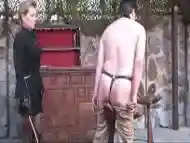 Lady with leathered miniskirt canes slave