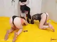 Submissive sluts balance piss buckets on their heads while sucking toes